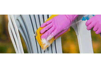 muž čistí zelenou plastovou židli