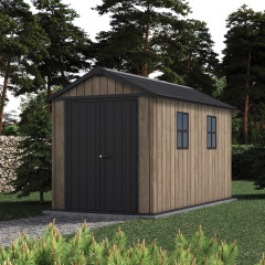 Zahradní domek Keter DECO APEX 7511 Ashwood v barvě dřeva s černou střechou a dveřmi umístěný na zahradě mezi stromy