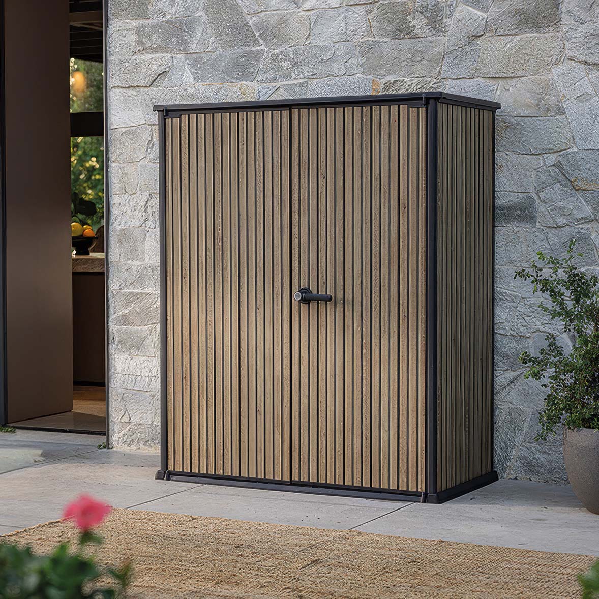 Zahradní úložný box Deco Vertical 1400L Venetian Brown v hnědé barvě s vertikálním žebrováním stojící na venkovní terase