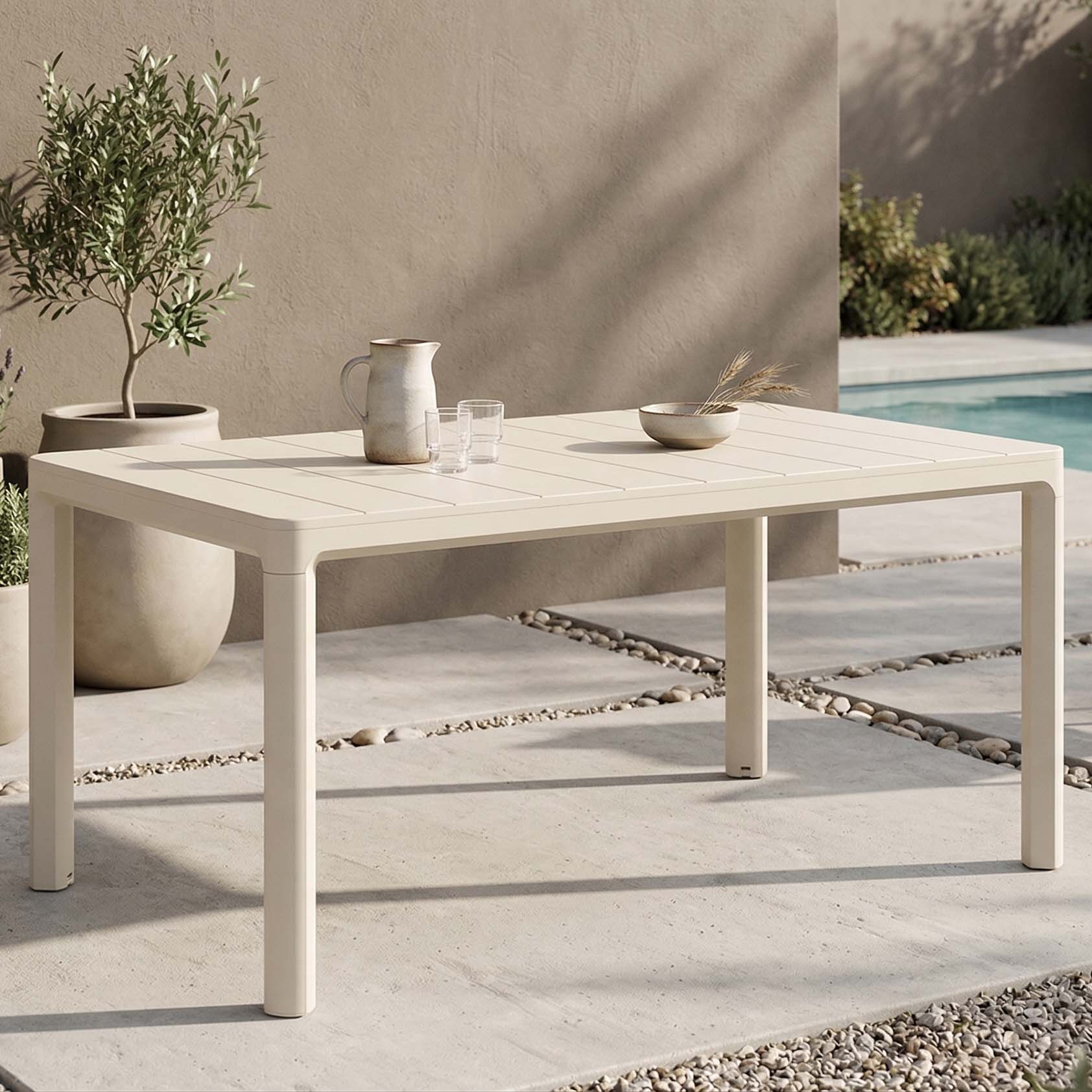 Zahradní stůl Keter SCANDI DINING v barvě Soft Beige na terase u bazénu s dekoracemi na desce
