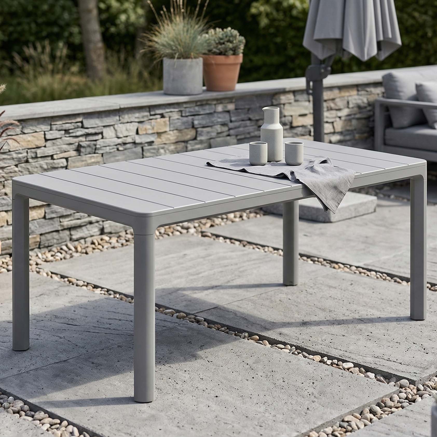 Obdélníkový zahradní stůl Keter Scandi Dining v barvě storm grey na terase s nádobím na desce