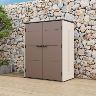 Zahradní skříň DAKOTA 4.7x2.5 Brown v hnědé barvě stojí na dřevěné terase před kamennou zdí