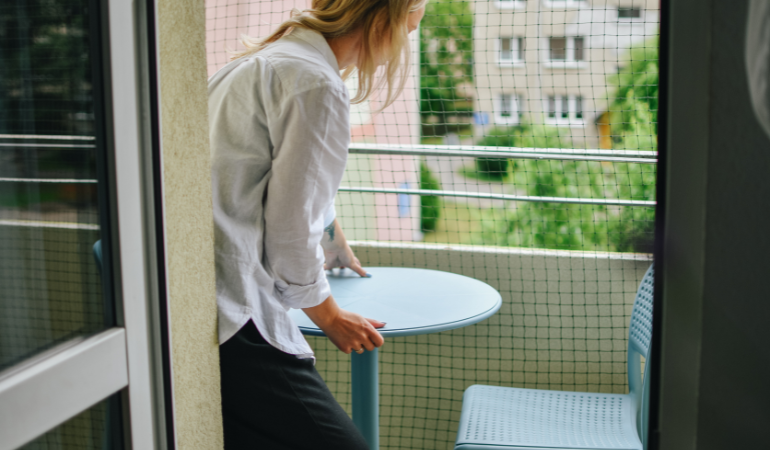 žena umisťuj&iacute;c&iacute; konferenčn&iacute; stolek na balkon