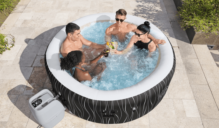 čtyři př&aacute;tel&eacute; relaxuj&iacute;c&iacute; ve v&iacute;řivce na zahradě