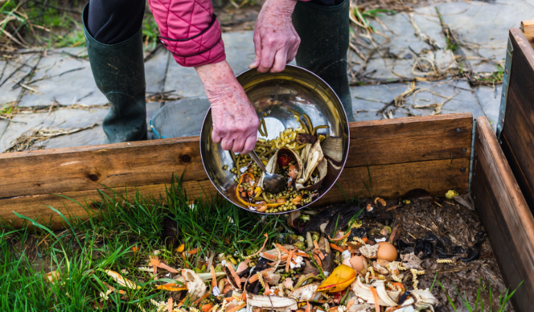 zahradník likviduje bioodpad v otevřeném kompostéru.