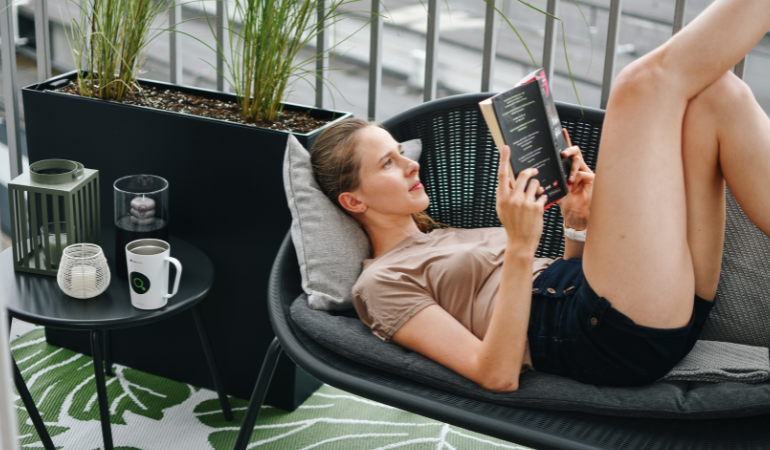 žena relaxuj&iacute;c&iacute; na balkonu ve stylu loft