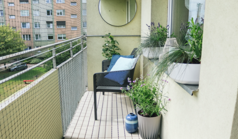wąski balkon w bloku z meblami 