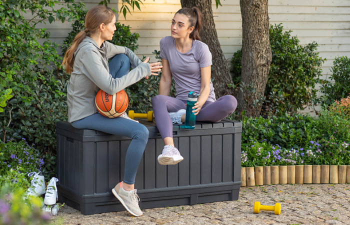 ženy po tréninku sedí na zahradě na zahradním boxu