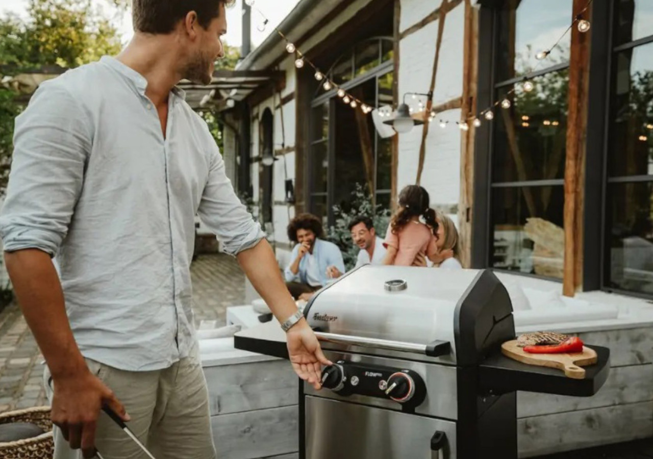 Elektrick&yacute; gril eFlow PRO 2 Turbo - ENDERS muž stoj&iacute; u zavřen&eacute;ho grilu na terase